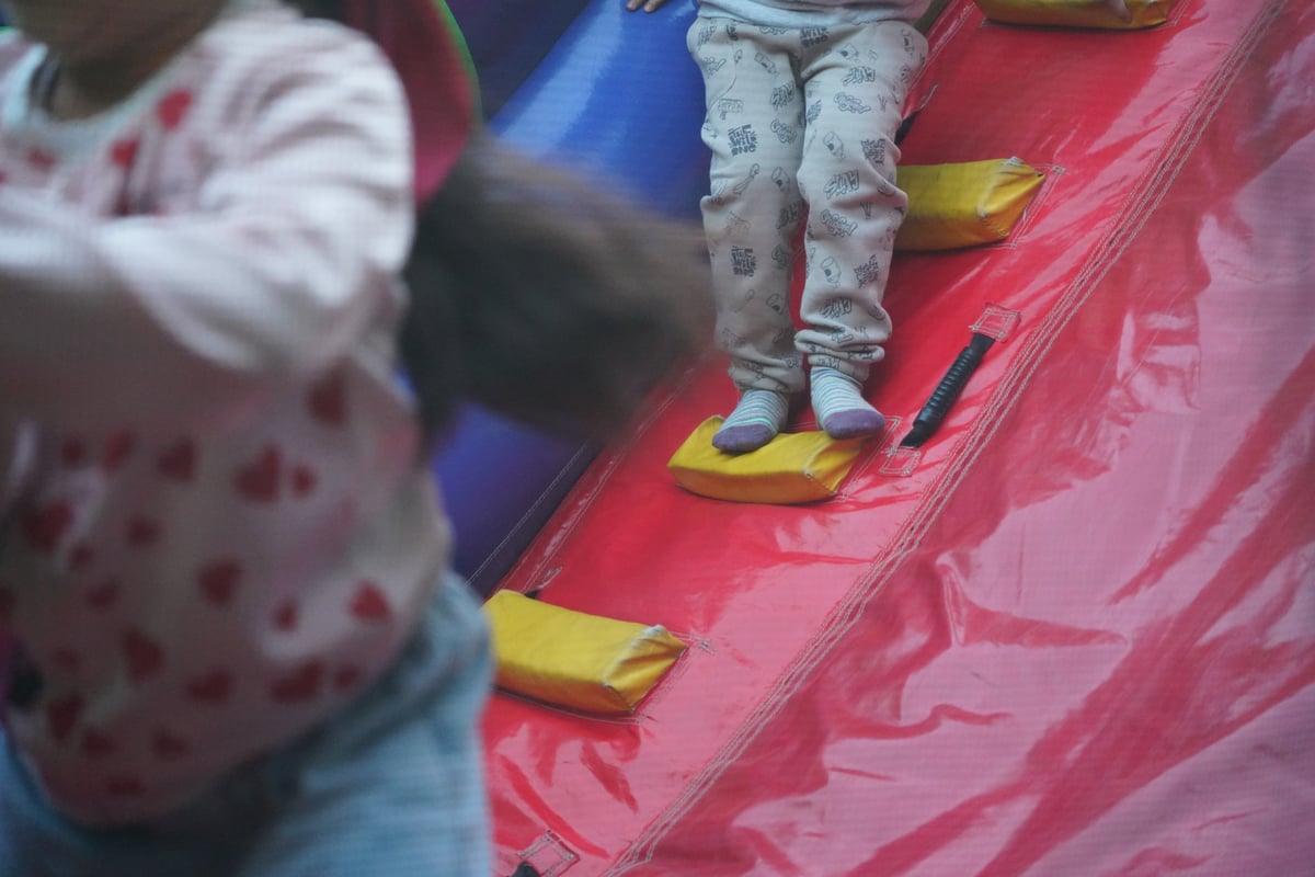 Happy children jumping and playing together on colorful inflatable bounce house games